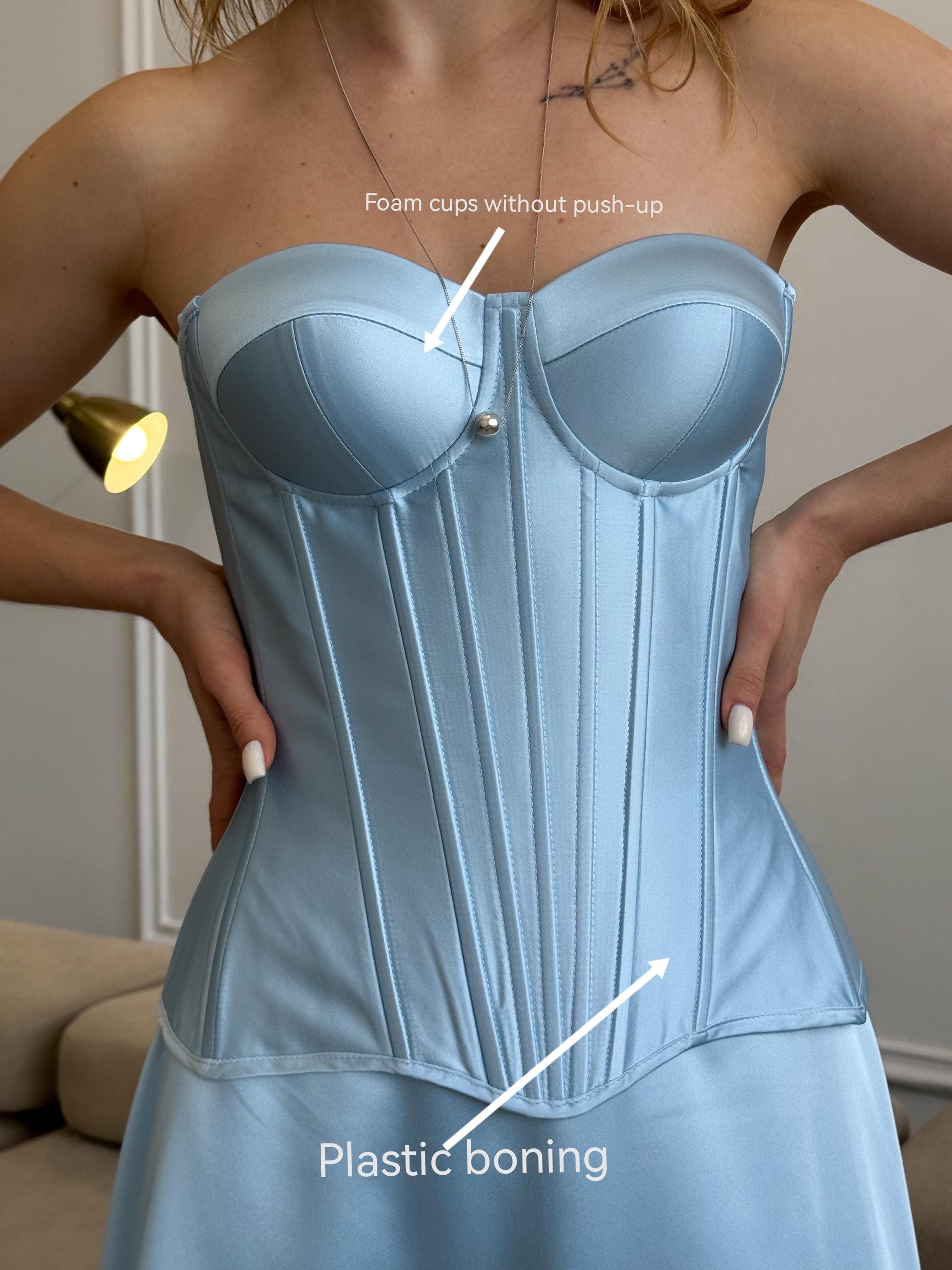 a woman wearing a blue corset and a necklace